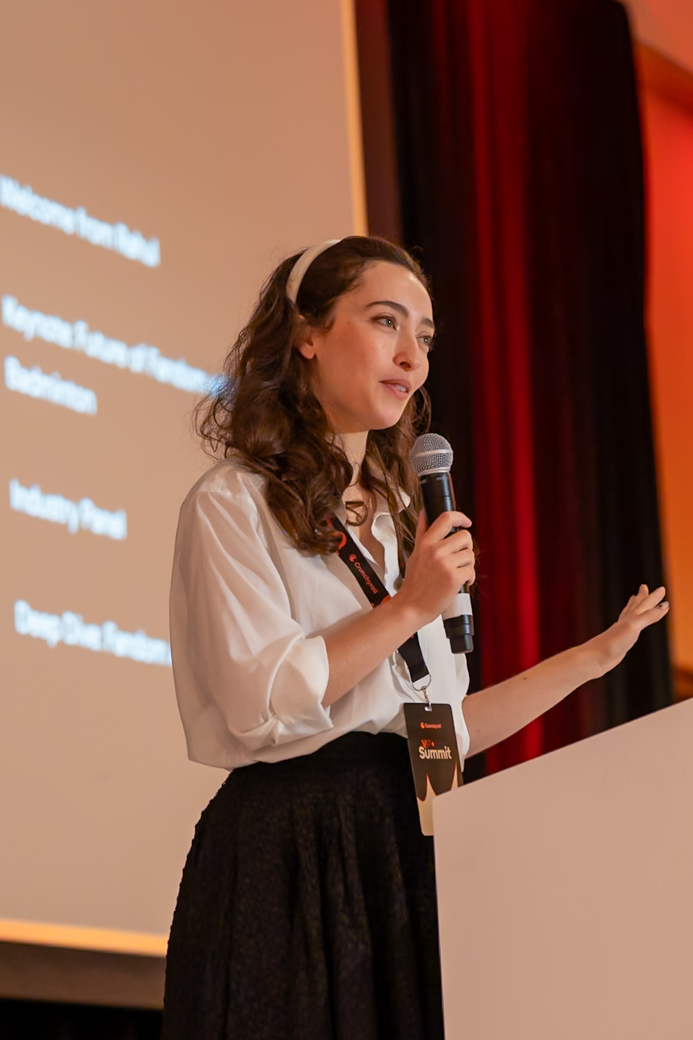 Danielle Frider speaking on stage at a summit